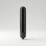 A sleek, glossy black cylindrical electronic adult vibrator with a rounded top and a small circular button near the base, standing upright on a small round foot against a light grey studio background.