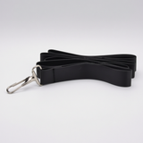 A black fabric strap - adults' play leash - with a silver metal swivel clasp, photographed on a clean light gray studio background. As part of an adult couples' bondage kit. 
