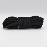 A coiled bundle of thick black braided rope to be used as part of a bondage kit for adults, secured with a black wrap, photographed on a clean light grey studio background. 5 Metre Length.